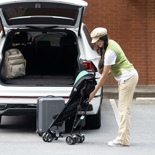 Woman loading a stroller and suitcase into the back of a car.